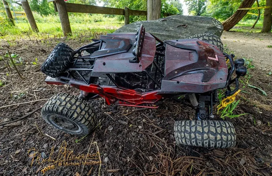 Dark red RC rock crawler buggy climbing over a boulder on the off-road course at RC World Adventures St. Jacobs